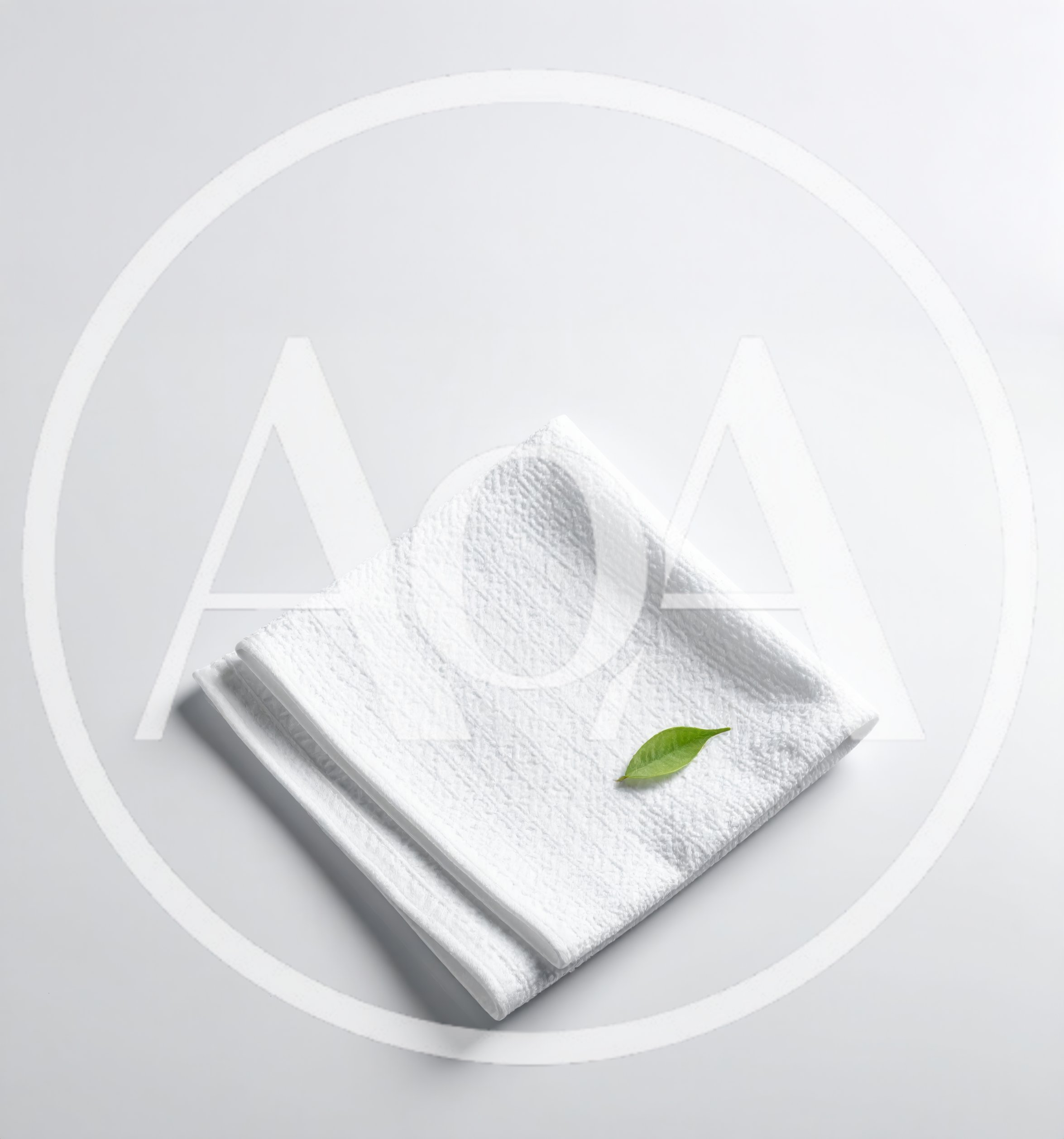 White Folded Towel With A Single Green Leaf