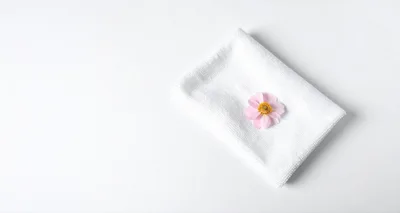 Pink Flower Resting On A White Folded Towel
