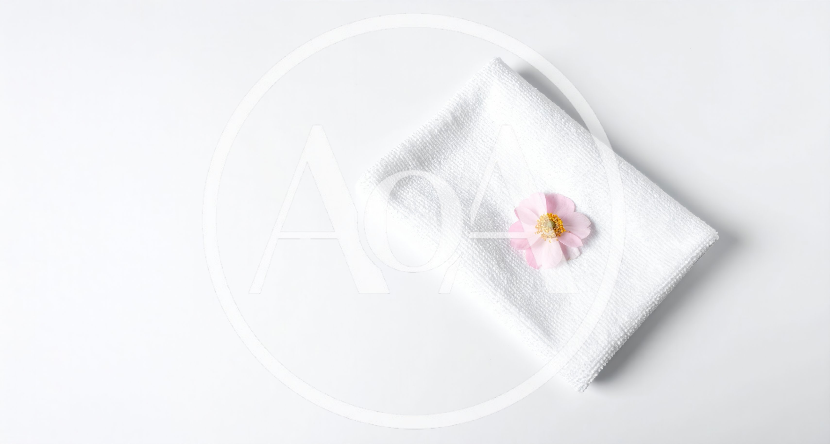 Pink Flower Resting On A White Folded Towel