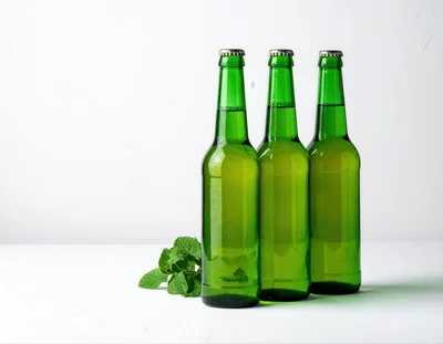 Three Green Glass Beer Bottles With Mint Leaves