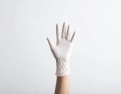 Hand Wearing A White Medical Latex Glove
