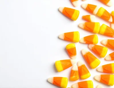 Candy Corn Pieces Scattered on White Background