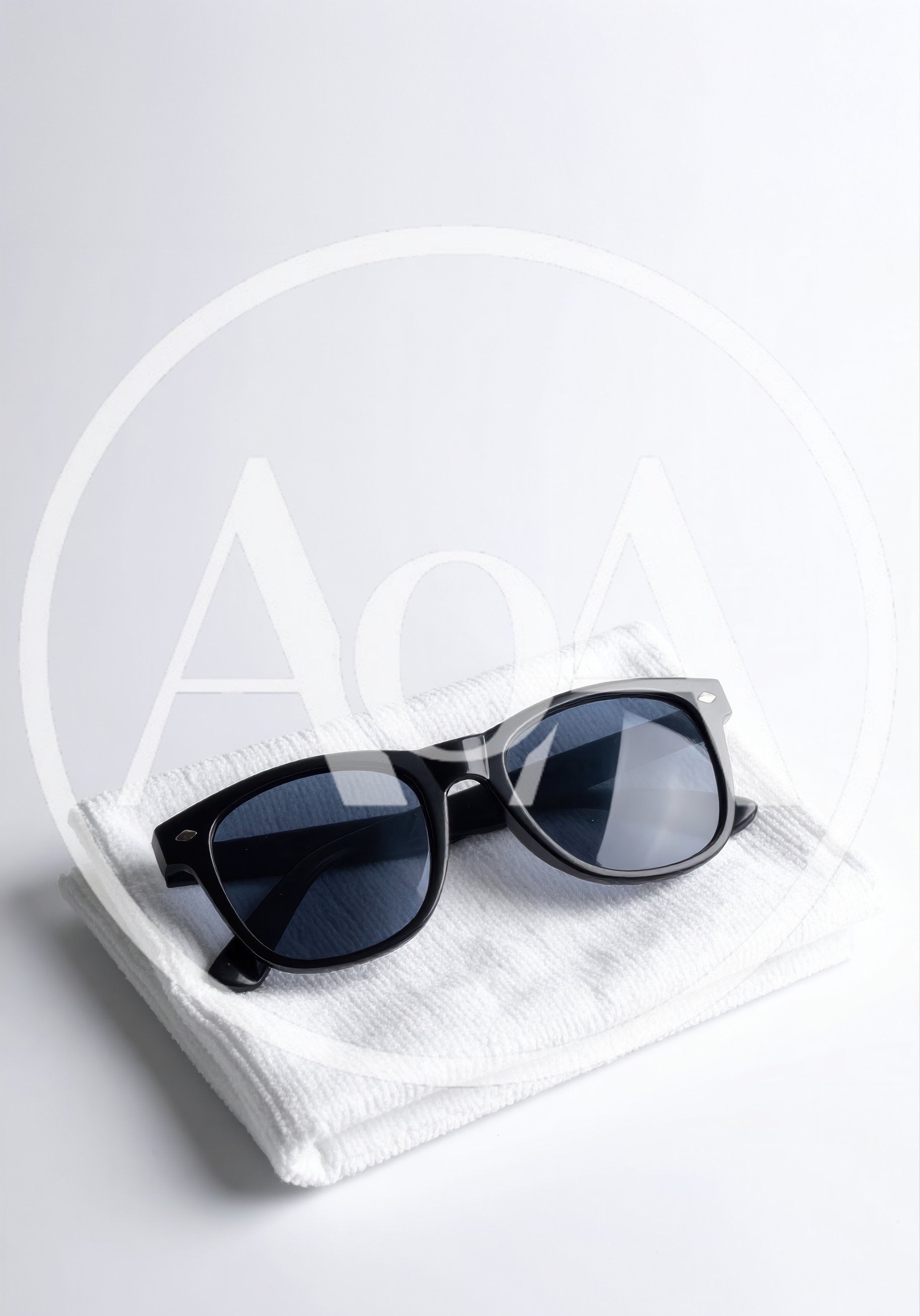 Black Sunglasses Resting On A Folded White Towel