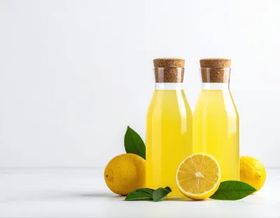 Two Bottles Of Fresh Lemonade With Whole And Sliced Lemons