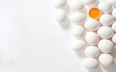Group of White Chicken Eggs with One Cracked Egg