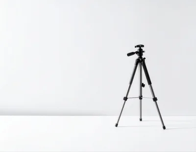 Black Camera Tripod Standing On White Surface
