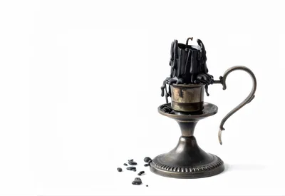 Black Candle Melting In An Antique Brass Candlestick