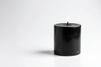 Lit Black Pillar Candle On White Background