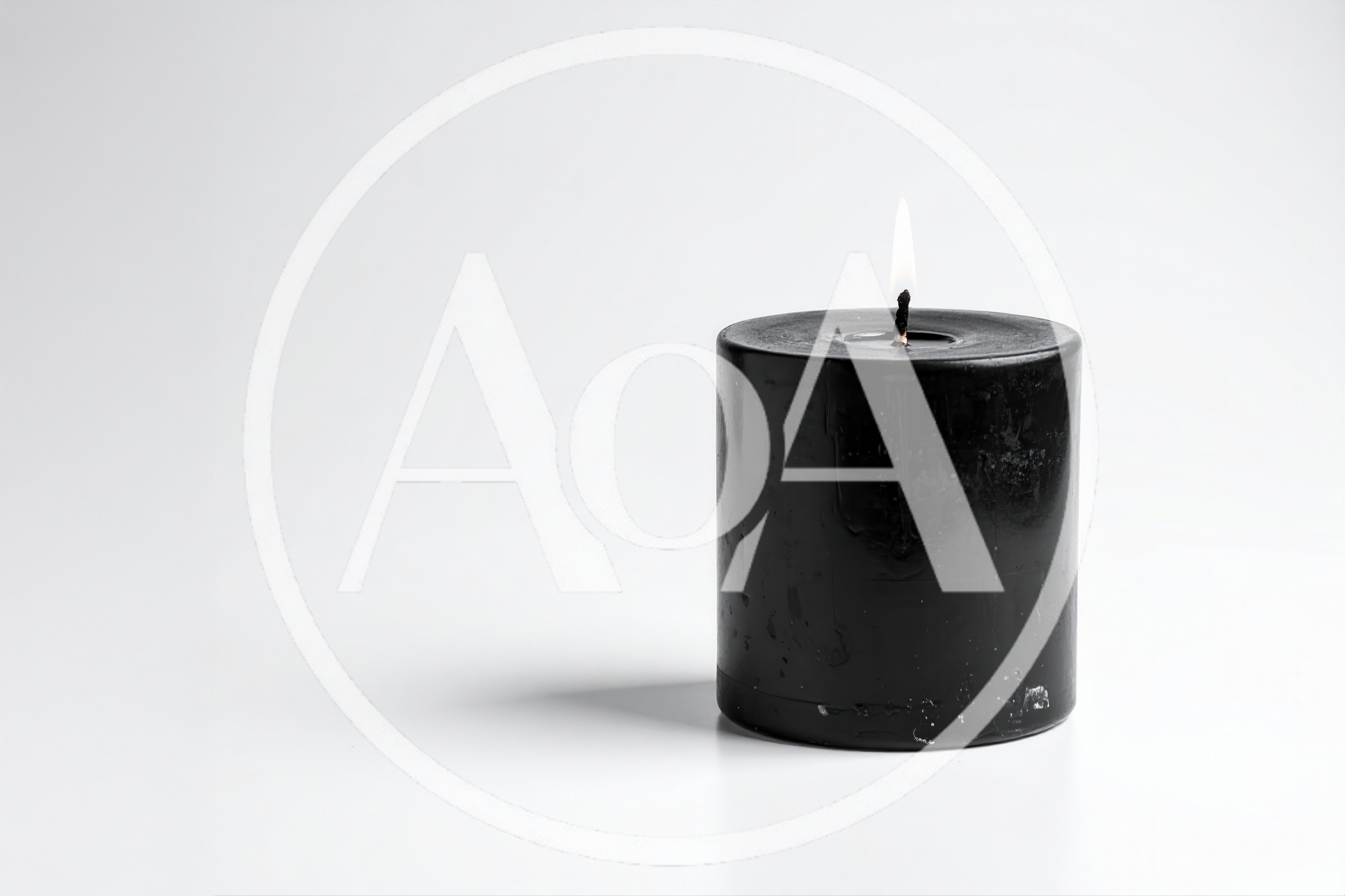 Lit Black Pillar Candle On White Background