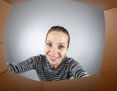 Woman Looking Into A Cardboard Box