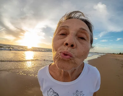 Elderly Woman Making A Kissing Face On The Beach