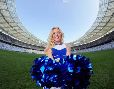 Cheerleader Holding Blue Pom Poms On Stadium Field