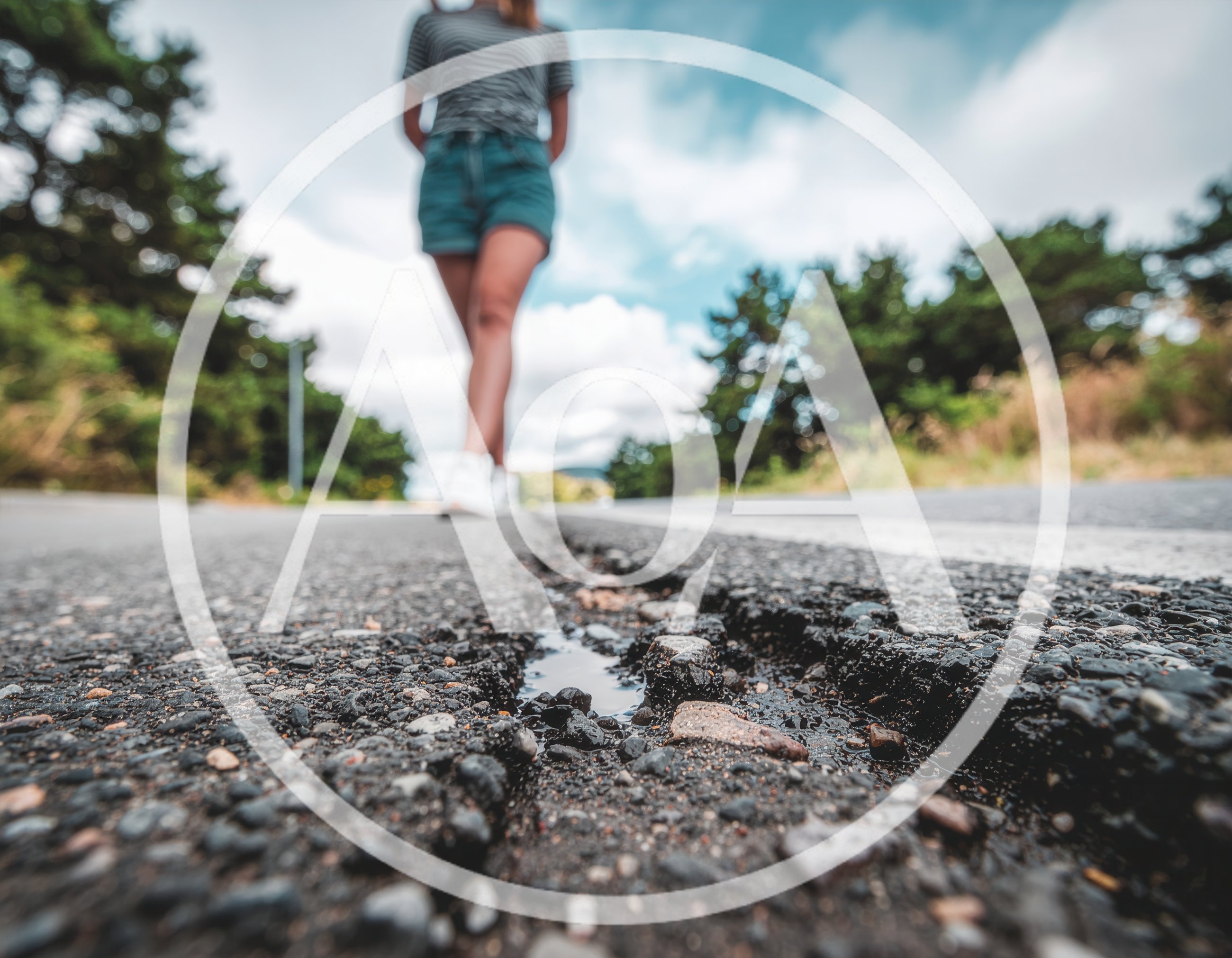 Woman Walking Along A Damaged Asphalt Road
