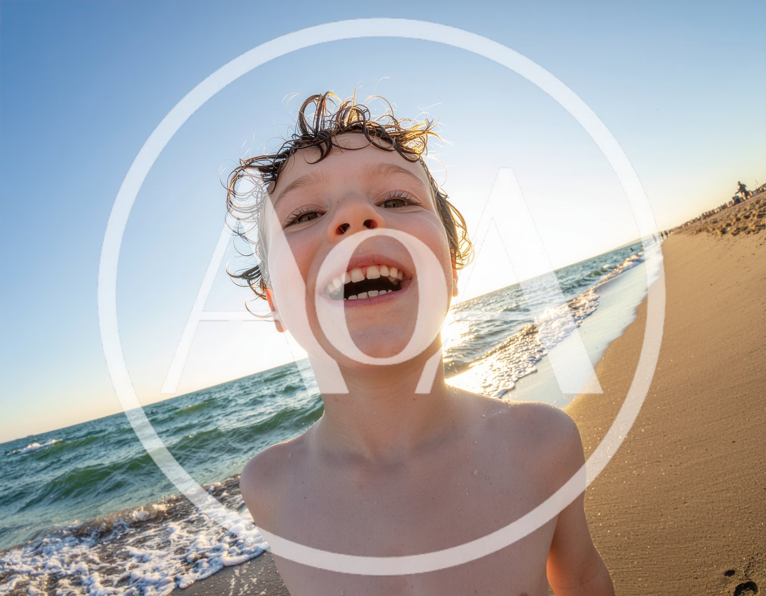 Happy Young Boy Smiling On Sunny Beach