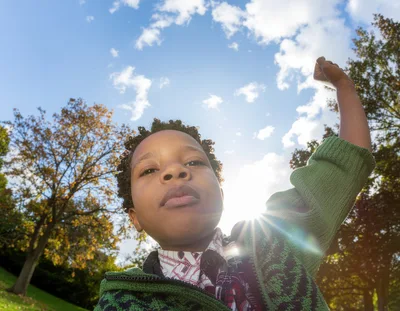 Young Boy Raising Fist In Celebration Outdoors