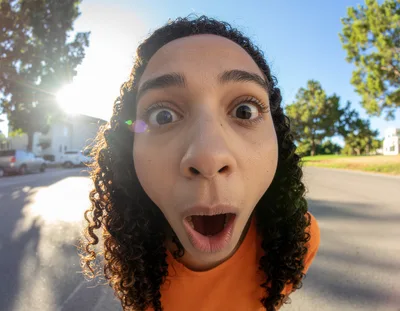 Young Person With Curly Hair Making Surprised Expression