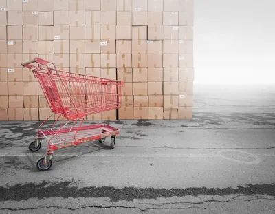 Red Shopping Cart Standing Before A Large Stacked Wall