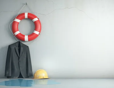 Lifebuoy Suit And Hard Hat On Concrete Wall