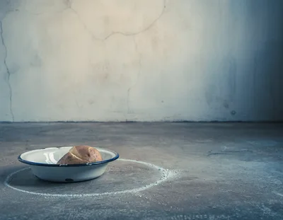 Single Potato In A Metal Bowl On Concrete Floor