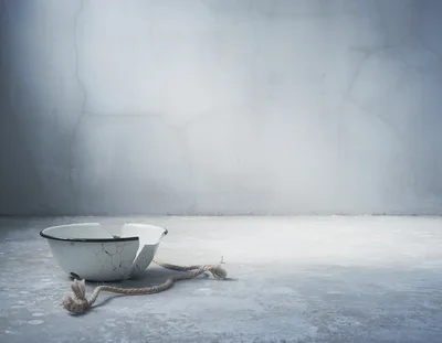 Broken Enamel Bowl With Rope On Concrete Floor