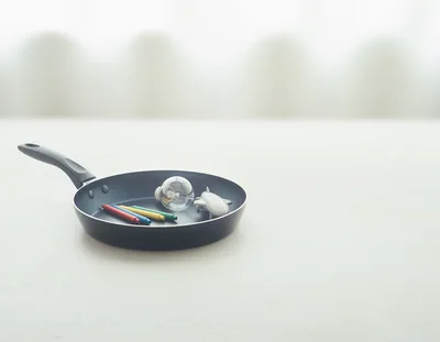 Light Bulb Crayons and Toy Airplane in Frying Pan