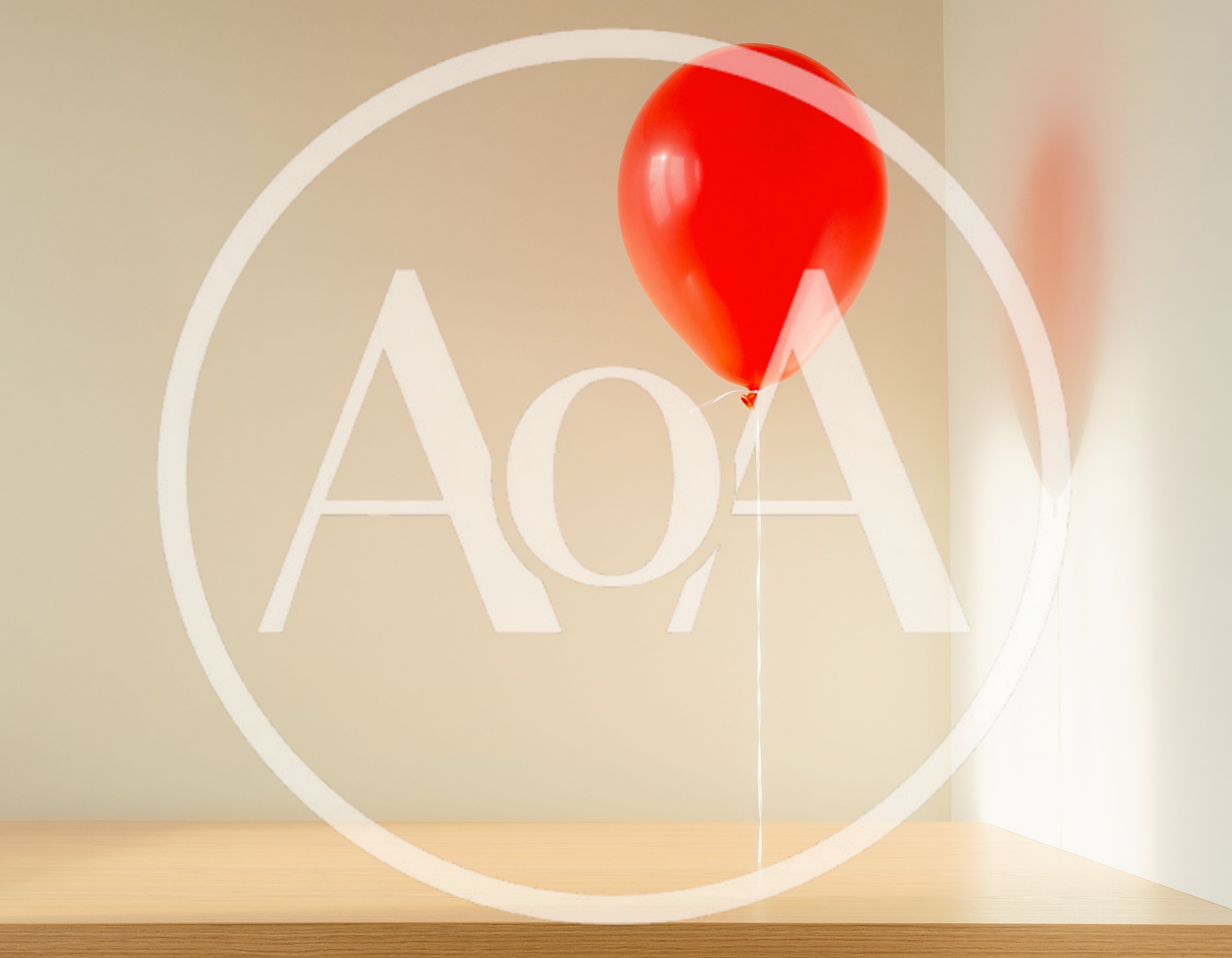 Single Red Balloon Floating Above Wooden Table