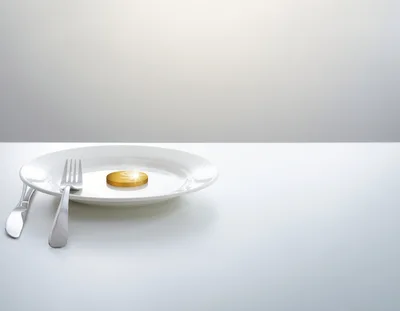 Gold Dollar Coin Served on a White Dinner Plate
