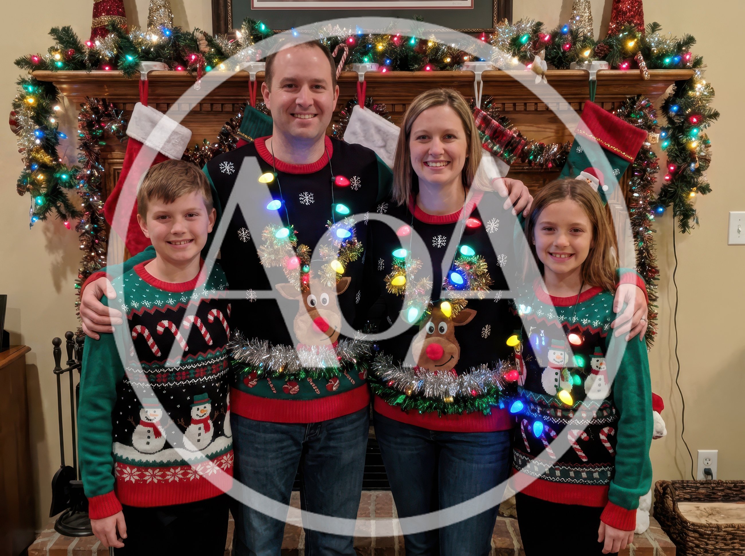Family Posing In Matching Christmas Sweaters By Fireplace