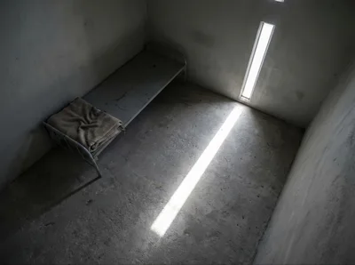 Empty Prison Cell With Metal Bed Frame