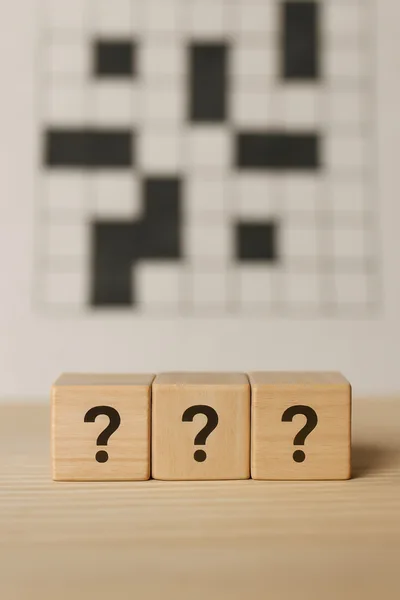 Three Wooden Blocks With Question Marks In Front Of Crossword