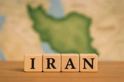 Wooden Blocks Spelling Iran In Front Of Map