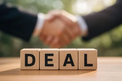 Business Handshake Behind Wooden Blocks Spelling Deal