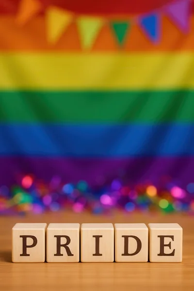 Wooden Blocks Spelling Pride With Rainbow Flag Background