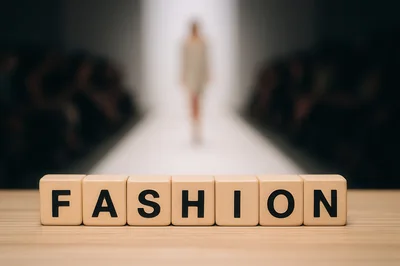 Wooden Blocks Spelling Fashion on a Runway Background
