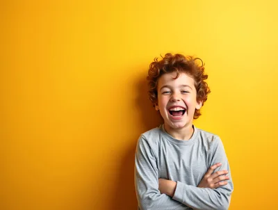 Happy Young Boy Laughing Against Yellow Background