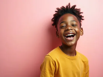 Happy Young Boy Laughing Against Pink Background