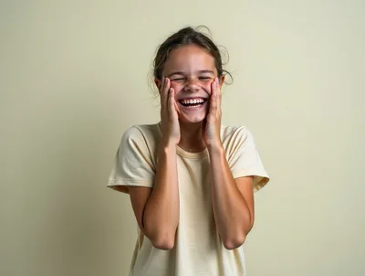 Young Girl Laughing With Hands On Her Cheeks