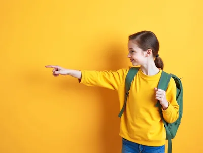 Young Girl Pointing To The Side With Backpack