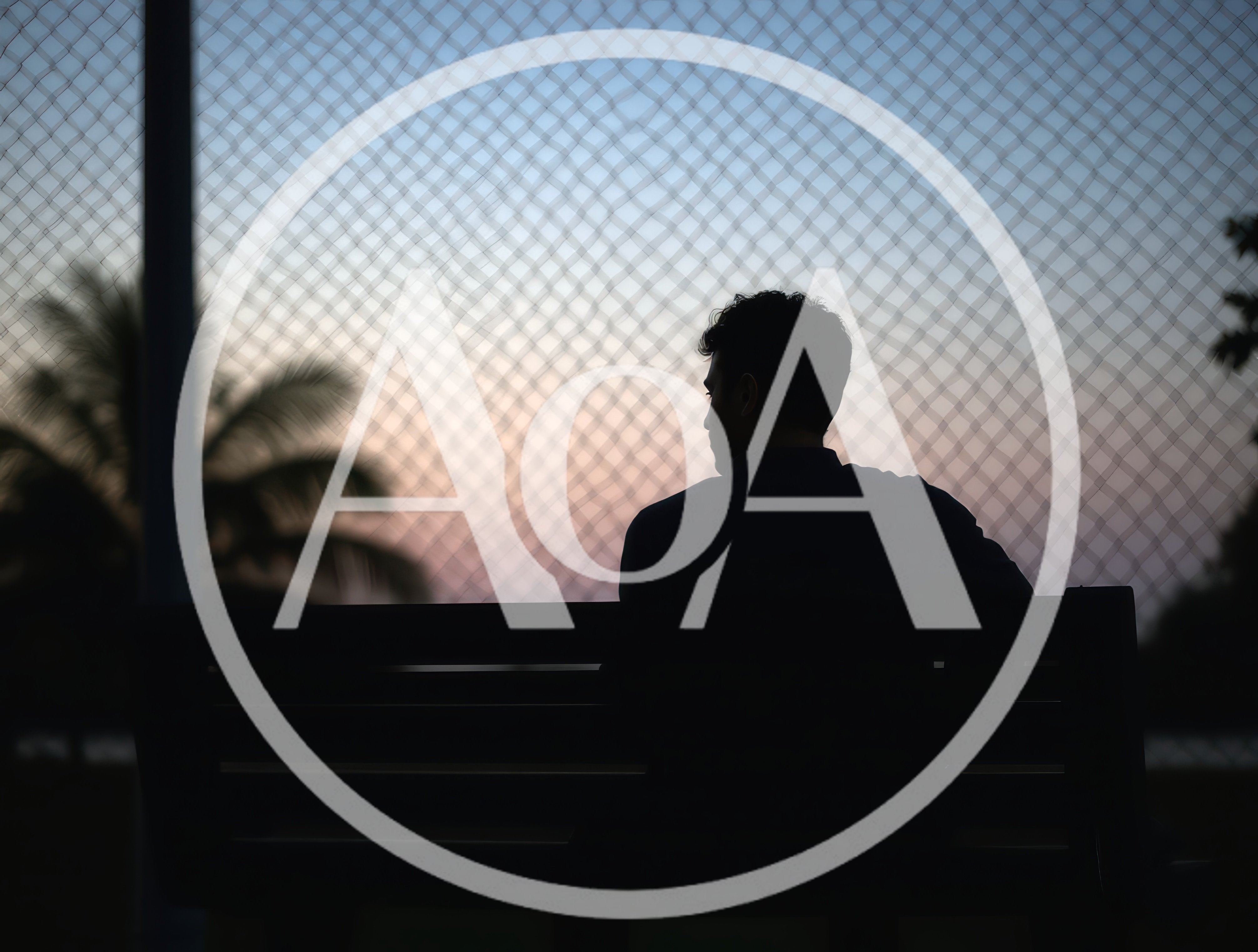 Silhouette of a Man Sitting on a Park Bench