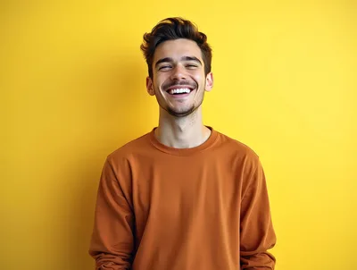 Happy Young Man Laughing Against Yellow Background