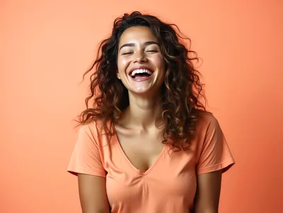 Happy Young Woman Laughing Against Peach Background