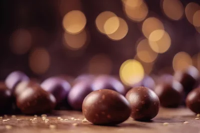 Chocolate Easter Eggs on Wooden Surface with Bokeh Lights
