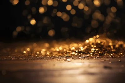 Golden Glitter Particles Falling On Dark Surface