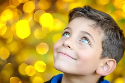 Young Boy Looking Upwards With A Joyful Expression