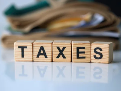 Wooden Blocks Spelling Taxes On Reflective Surface
