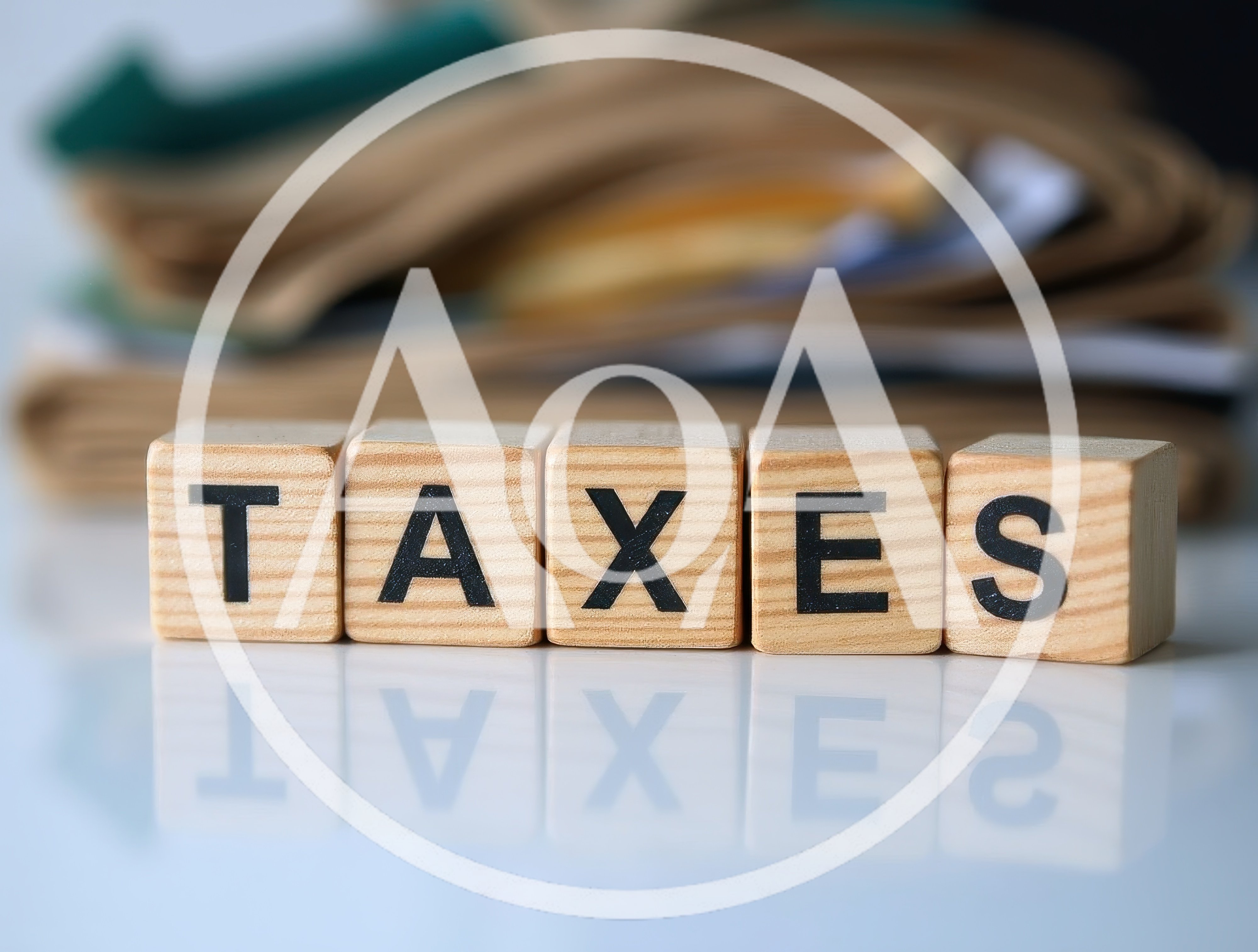 Wooden Blocks Spelling Taxes On Reflective Surface