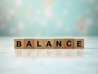 Wooden Blocks Spelling Balance On Reflective Surface