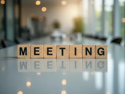 Wooden Blocks Spelling Meeting On A Reflective Office Table
