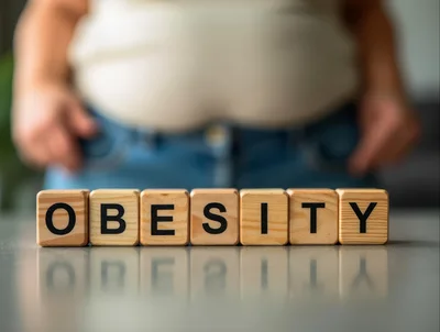 Wooden Blocks Spelling Obesity In Front Of Overweight Person