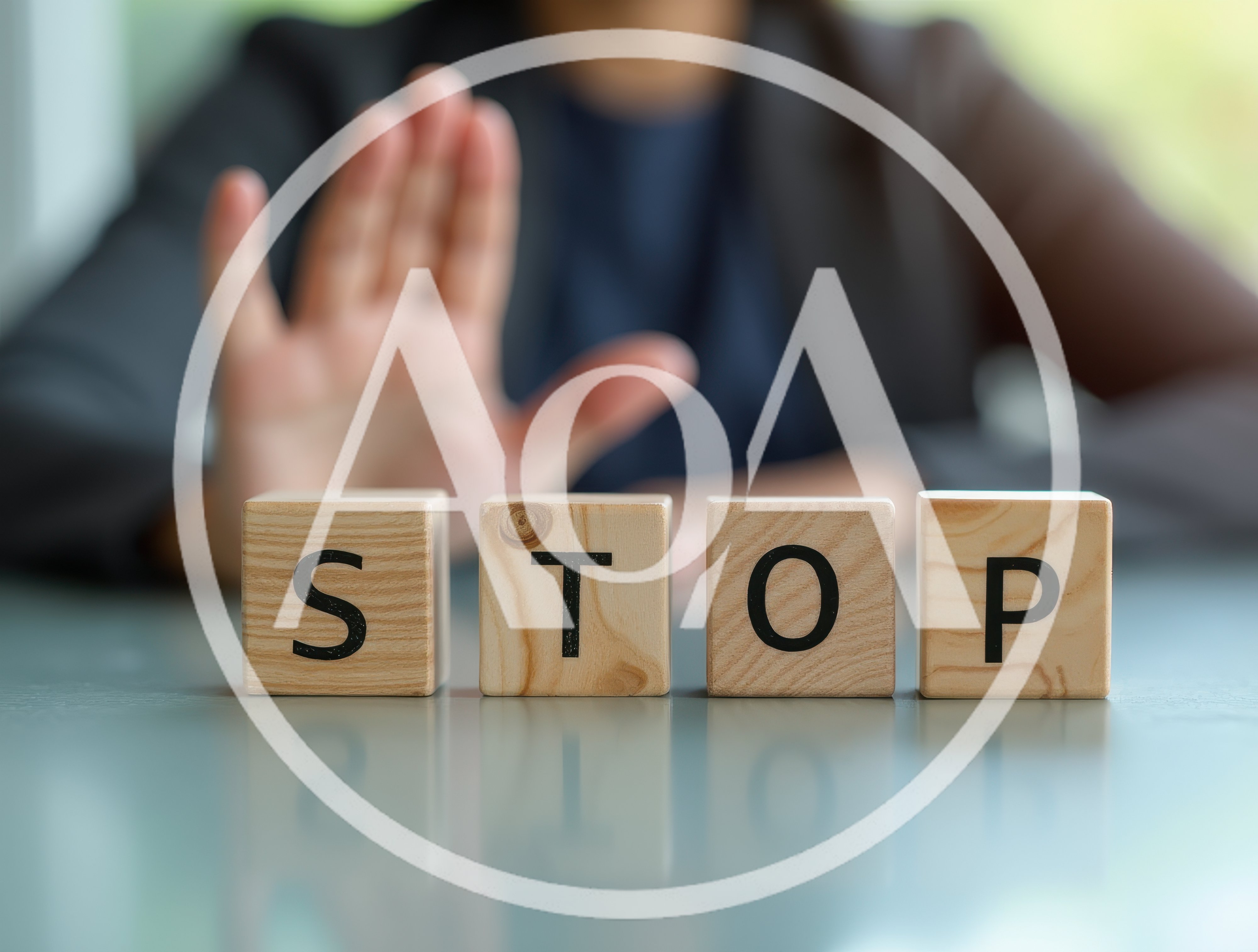 Business Person Making Stop Gesture Behind Wooden Blocks